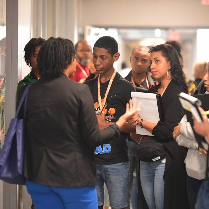 Student Tour 2019 Youth taking notes and listening on a tour.